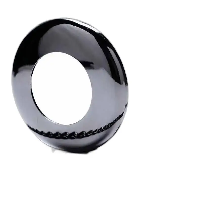 Vaso a ciambella nero lucido in armonia con un orologio da tasca dal design unico